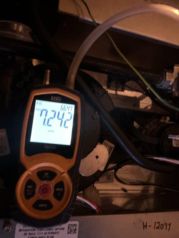 Performed furnace maintenance and verified system operation using a UEi EM720 digital manometer to measure pressure readings, including inlet gas pressure at the gas valve (approximately 7.2 inH2O) and a secondary differential pressure reading of 0.157 inH2O. Inspected the burner compartment, wiring harnesses, and inducer assembly, and confirmed all measurements were within normal operating parameters for safe and efficient heating performance.