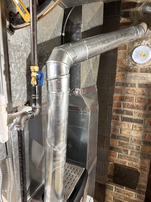 Installed a new 80% AFUE gas furnace with a galvanized flue connected to the existing masonry chimney, and reconnected the gas supply through a shutoff valve and the condensate/drain piping. Installed an AprilAire media air filter cabinet, verified static pressure across the filter with a digital manometer, and sealed the sheet metal duct seams with foil tape. Also installed a whole-home surge protector.