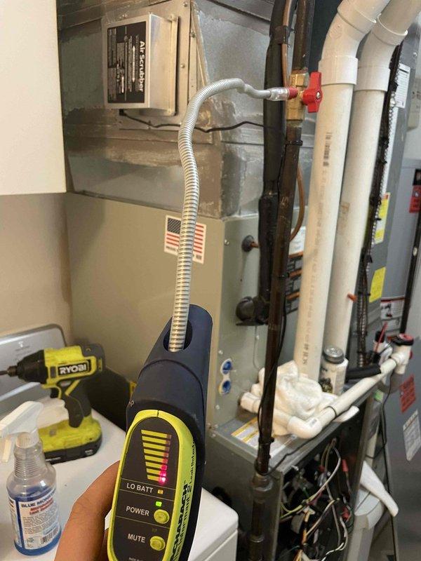 Responded to a gas odor complaint near furnace system. Conducted leak detection investigation using electronic gas detector, inspecting furnace connections and adjacent utility areas including behind laundry appliances. Testing identified gas leak source which was repaired. Customer was advised of findings and warranty company was contacted as requested with detailed report of service performed.