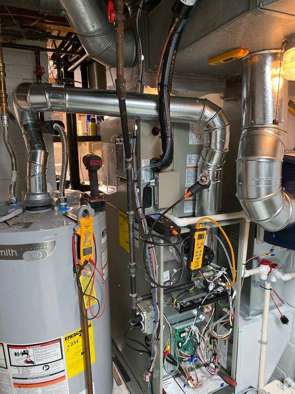 Completed installation of a complete HVAC system as a return job sold by Greg and flipped by Sam Kdz. System includes new furnace, ductwork, and connections to existing 100-gallon Smith water heater. Post-installation temperature verification confirmed proper operation with supply air temperature at 71.0°F.