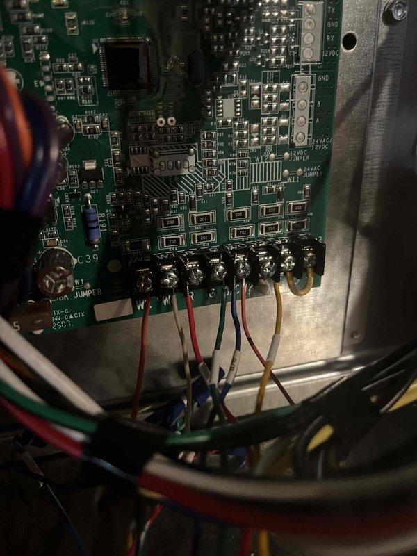 Completed installation of new HVAC system with control board wiring connections properly secured and color-coded (red, white, blue, green, yellow). Installed copper refrigerant lines with proper insulation and shutoff valve, and set up collection tray for condensate drainage. Water heater was left in original packaging per customer request from sale by Greg.