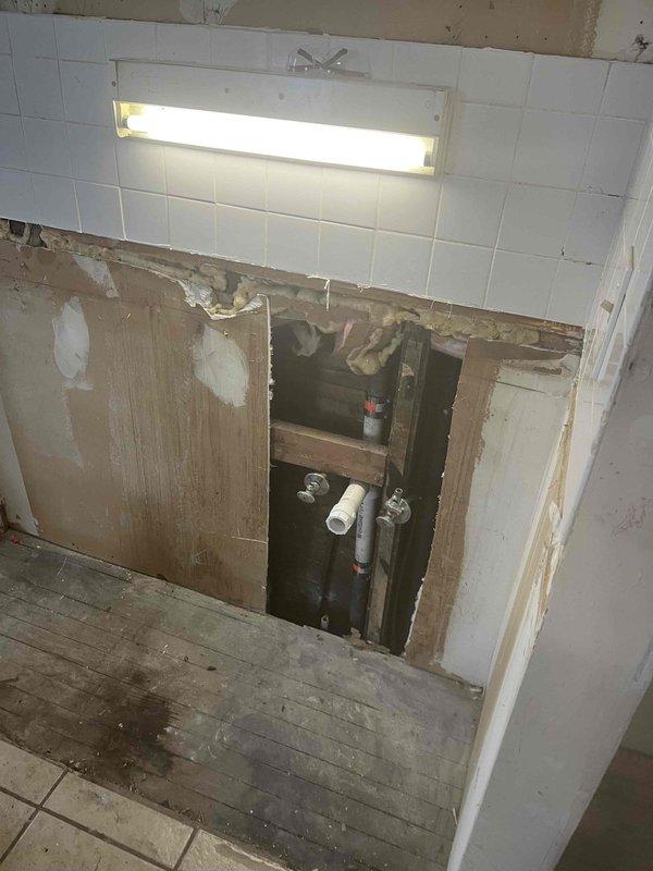 Responded to service call in Unit #5 regarding broken kitchen drain. Visual inspection revealed damaged stack in the wall requiring replacement. Performed partial wall demolition to access the plumbing infrastructure, exposing PVC and metal pipes. Successfully replaced the broken drain stack and verified proper function of connected valves and drainage system.