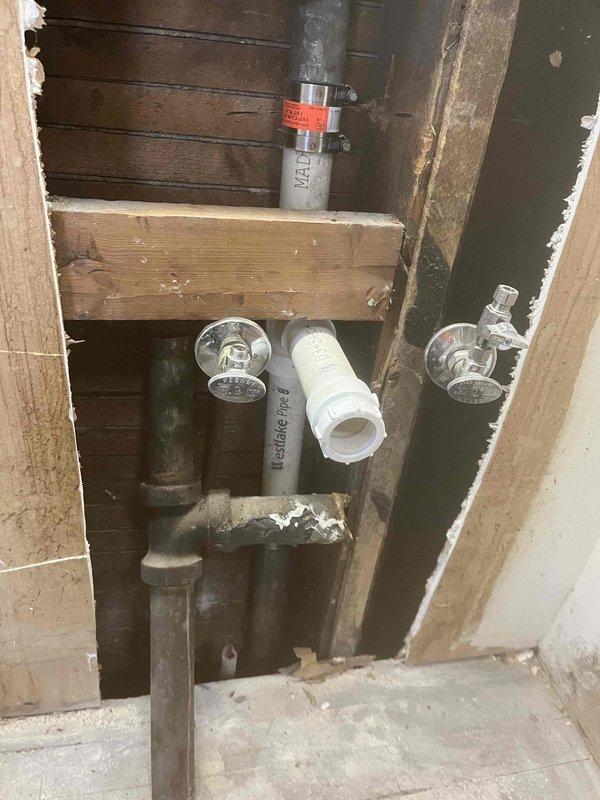 Responded to service call in Unit #5 regarding broken kitchen drain. Visual inspection revealed damaged stack in the wall requiring replacement. Performed partial wall demolition to access the plumbing infrastructure, exposing PVC and metal pipes. Successfully replaced the broken drain stack and verified proper function of connected valves and drainage system.