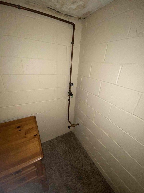 Conducted water quality assessment in basement utility area due to customer complaint of "bad tasting water." Inspection revealed old copper pipe system with significant oxidation and possible corrosion. Identified potential sources of water contamination including aging pipes with rusty appearance, visible brass fittings, and ceiling water damage that could be affecting water supply.