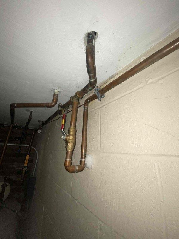 Conducted water quality assessment in basement utility area due to customer complaint of "bad tasting water." Inspection revealed old copper pipe system with significant oxidation and possible corrosion. Identified potential sources of water contamination including aging pipes with rusty appearance, visible brass fittings, and ceiling water damage that could be affecting water supply.