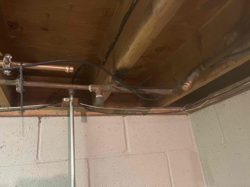 Diagnosed 25-year-old Kenmore water treatment system with complete water flow obstruction. Inspection revealed significant corrosion and mineral buildup on copper supply lines and valves, particularly at connection points where extensive verdigris had developed. Determined system failure due to age-related deterioration and mineral deposits blocking water intake.