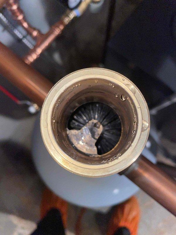 Completed return visit to install magnetic filter on boiler system as previously sold. Added inhibitor to system as recommended. Observed debris accumulation inside existing fittings, indicating potential scale buildup in the system. Filter installation will help prevent further circulation of particulate matter and extend system lifespan.