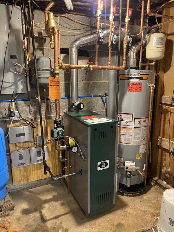 Successfully installed a Peerless Mi-X 03 84% efficiency boiler with three zone valves and WiFi thermostats. System includes Honeywell Home controls mounted on wooden panel with proper electrical connections. Additional plumbing repairs were completed and a new hot water tank was installed with all copper piping properly connected and pressure-tested.