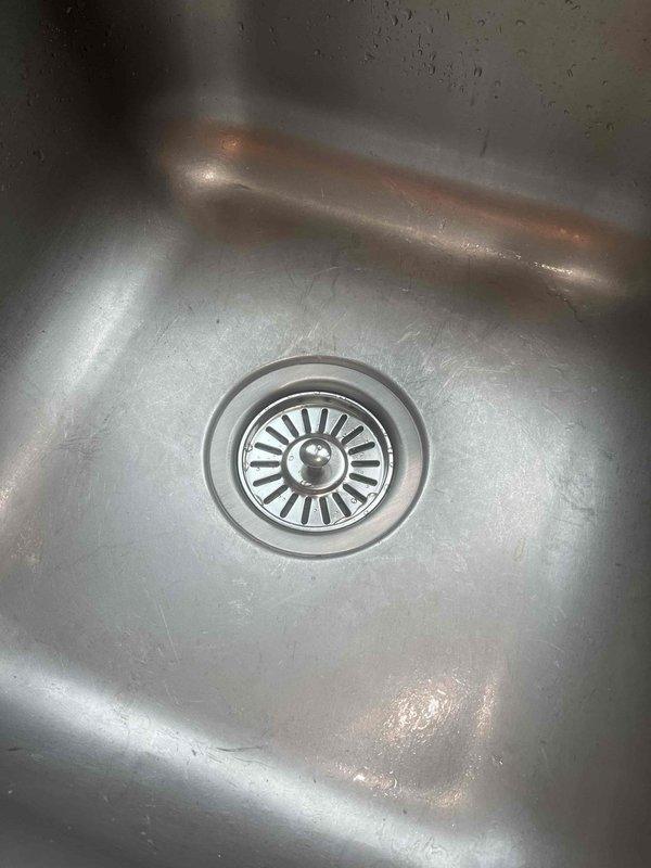 Responded to warranty claim #30631637 for non-functioning, leaking garbage disposal. Inspected the 1/2 HP heavy duty unit mounted under stainless steel kitchen sink. Documented existing condition with detailed photos of sink drain assembly and disposal motor housing for warranty company verification.