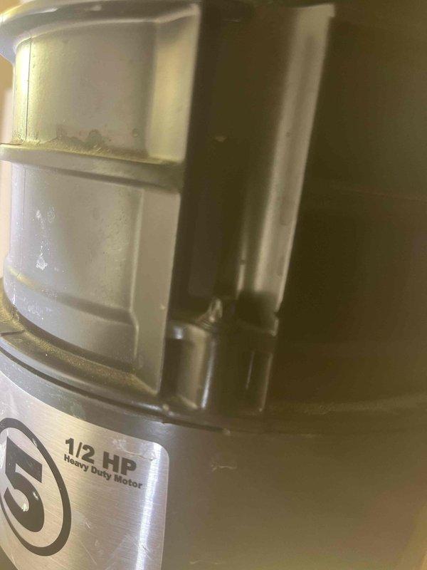 Responded to warranty claim #30631637 for non-functioning, leaking garbage disposal. Inspected the 1/2 HP heavy duty unit mounted under stainless steel kitchen sink. Documented existing condition with detailed photos of sink drain assembly and disposal motor housing for warranty company verification.