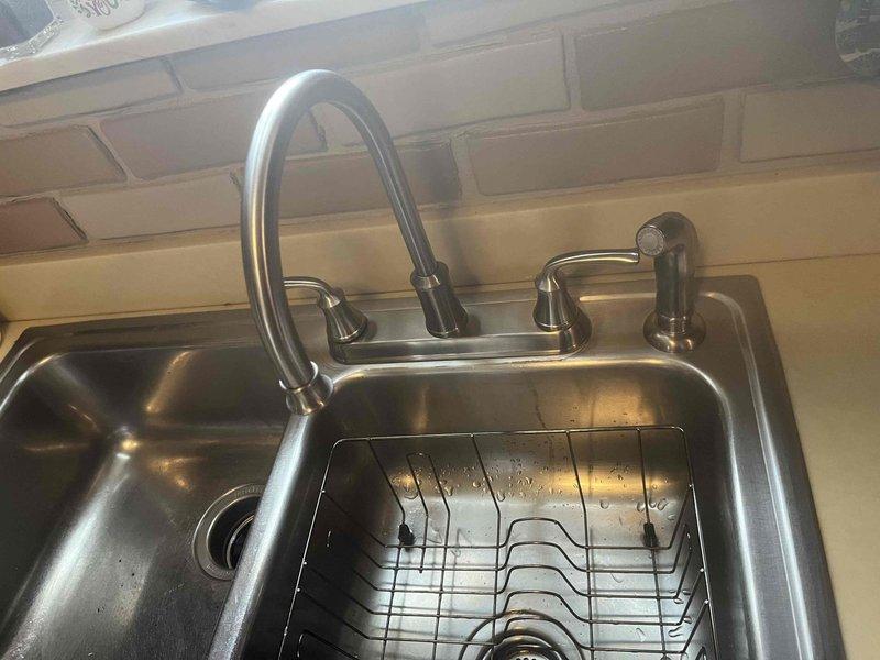 Replaced customer-supplied kitchen faucet, installing new high-arc pull-down sprayer model with proper water line connections. Also installed customer-supplied shower cartridge as requested, completing both installations with functional testing to ensure proper operation and no leaks.