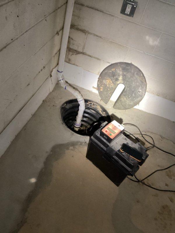 Responded to sump pump alarm activation. Inspected the system in basement, including the cast iron drainage pipes and sump pit. Found moisture around the sump basin indicating proper pump activation. Verified electrical connections and discharge pipe functionality to ensure system operating correctly.