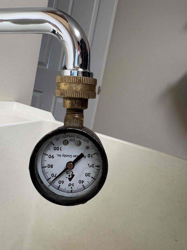 Repaired leaking hot water faucet in laundry tub. Used pipe cutter to access affected area and installed pressure gauge to verify system pressure after repair was completed. Successfully eliminated leak and restored normal water flow.