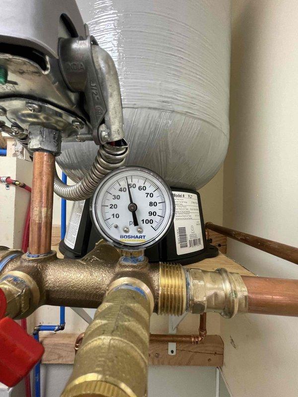 Responded to service call for water leak caused by pressure tank detachment from wall. Reinstalled 40-gallon expansion tank with proper wall mounting hardware and verified system pressure at 40-45 PSI. Tested all connections for leaks and confirmed proper operation of the complete water supply system.