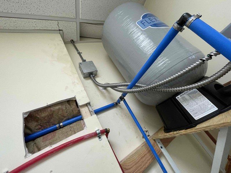 Responded to service call for water leak caused by pressure tank detachment from wall. Reinstalled 40-gallon expansion tank with proper wall mounting hardware and verified system pressure at 40-45 PSI. Tested all connections for leaks and confirmed proper operation of the complete water supply system.
