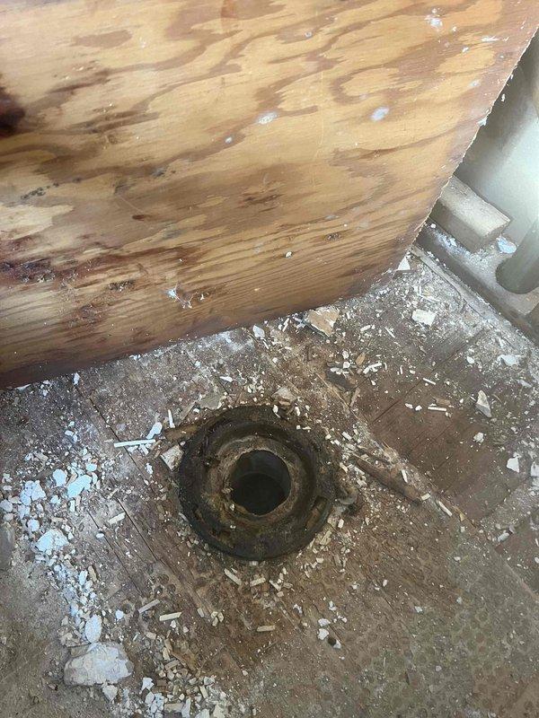 Responded to service call for bathroom pipe leak that had been ongoing for approximately one year. Upon inspection, found significant water damage to subfloor around shower drain with evidence of moisture penetration causing wood warping and possible mold formation. Repaired burst bathroom pipe, inspected surrounding PVC supply lines, and ensured proper sealing of the vapor barrier to prevent future moisture issues.