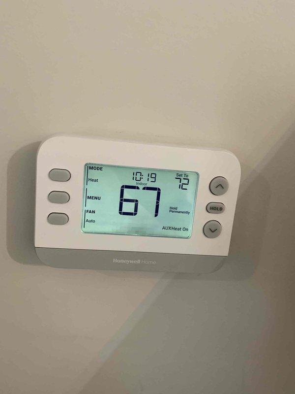 Responded to service call for 5-year-old heat pump system not reaching set temperature despite recent thermostat replacement. Diagnostic inspection revealed the system was properly engaging auxiliary heat mode (confirmed on Honeywell Home thermostat display showing "AUX Heat On") when attempting to raise temperature from 67°F to 72°F. Inspected American Standard electrical panel for proper connections and operation. System now functioning correctly with appropriate temperature differential.