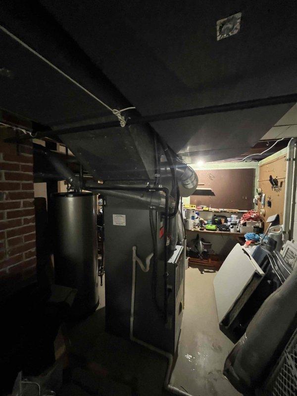 Completed inspection of residential HVAC system to diagnose uneven heating issues throughout home. Examined basement mechanical room containing furnace/air handler with connected ductwork system and photographed existing installation including brick wall area and galvanized metal ducts. Recommended mini-split system installation as solution to address temperature inconsistencies.