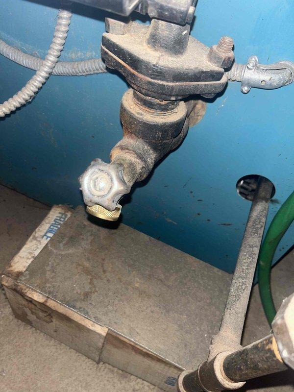 Responded to a no-heat call for a boiler system showing error code $65w AH on the thermostat. Inspection revealed worn valve assembly with surface corrosion on copper components. Serviced the control valve/regulator assembly and cleaned accumulated dirt from connection points. System restored to proper operation after component maintenance.