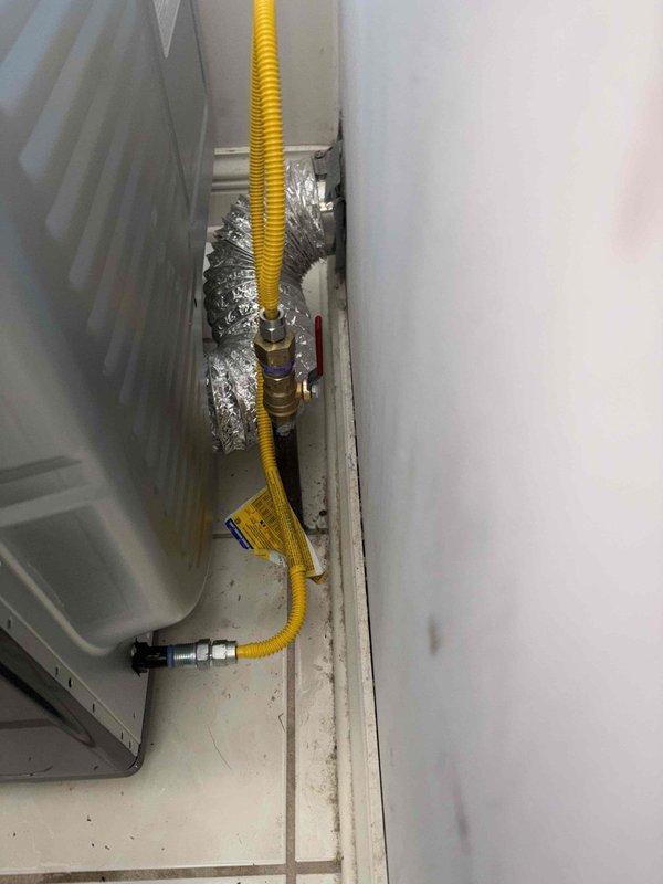 Installed new flexible yellow gas line with proper brass fittings to supply gas to customer's dryer. Connected line from existing black pipe with valve to the appliance, ensuring secure connections and proper routing through the utility area.