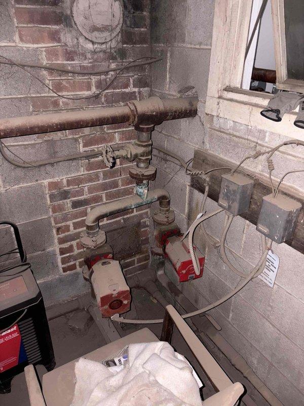 Conducted site inspection at NurseryTech to evaluate existing boiler system requiring repair. Documented significant pipe deterioration and corrosion, with measurements taken of clearance gaps between ceiling and damaged copper piping. Assessed mechanical room containing aging circulation pumps and associated plumbing infrastructure. Prepared comprehensive estimate for boiler repair options and additional quote requested for garage bay area heater installation.