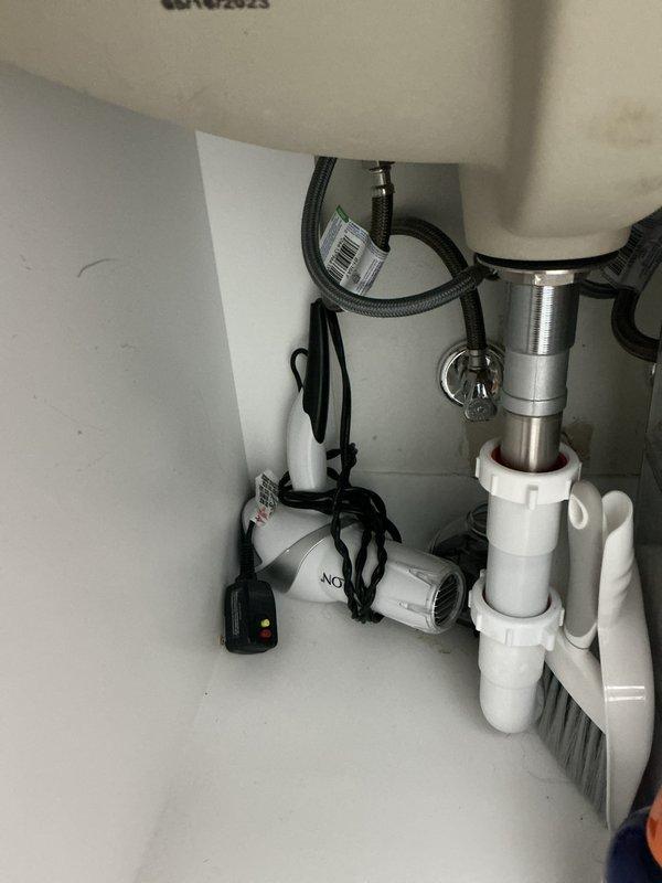 Performed follow-up service on previously sold tankless water heater maintenance. Customer reported water on vent; upon inspection, found no issues with the tankless unit. Examined under-sink plumbing including P-trap assembly and garbage disposal, confirming all components were properly connected with no active leaks or damage.