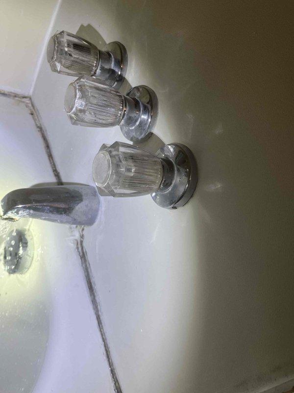 Responded to a water leak issue affecting ceiling. Upon inspection, found moisture damage in basement/crawlspace with standing water present. Located the source at a PVC pipe connection with distinctive orange/red banded valve. Repaired plumbing fixture to stop active leak and prevent further water damage to the property.