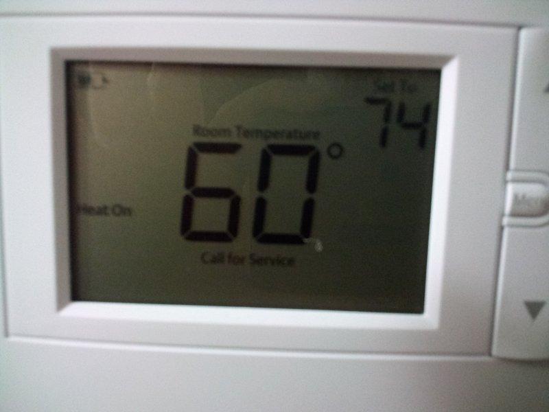 Diagnosed and repaired furnace leak causing system failure, evidenced by water pooling on basement floor and thermostat displaying "Call for Service" error. Restored heating functionality with thermostat now properly maintaining desired temperature (74°) after repair and system reset.