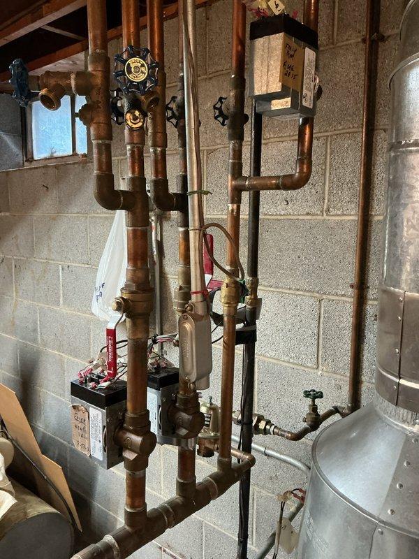 Inspected 12-15 year old Weil-McLain gas boiler system. Boiler is operational but identified a broken copper fitting prong on one of the zone valves requiring replacement. System has typical aging of copper components but maintains functionality with current configuration.
