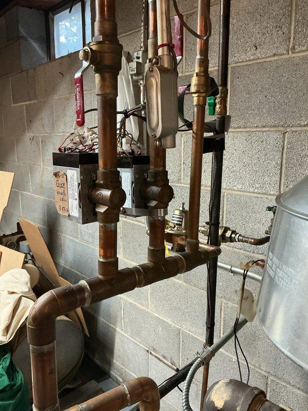 Inspected 12-15 year old Weil-McLain gas boiler system. Boiler is operational but identified a broken copper fitting prong on one of the zone valves requiring replacement. System has typical aging of copper components but maintains functionality with current configuration.