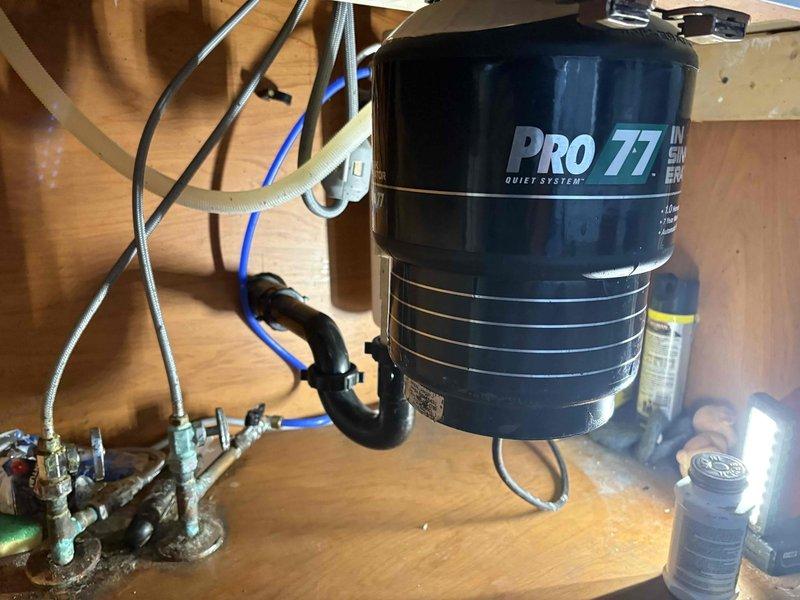 Responded to service call for clogged garbage disposal (PRO 77 Quiet System model). Inspection revealed significant debris buildup and brownish staining inside the disposal drain. Successfully cleared the clog and restored proper drainage functionality.