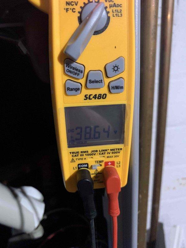 Responded to service call for non-functioning boiler with reported blower assembly error code. Performed electrical diagnostics with Fieldpiece SC480 multimeter, measuring 386.4V at input terminals. Inspected internal components and identified corrosion at pipe joint connections within the mechanical assembly. Cleaned corroded connections and restored proper operation of the heating system.