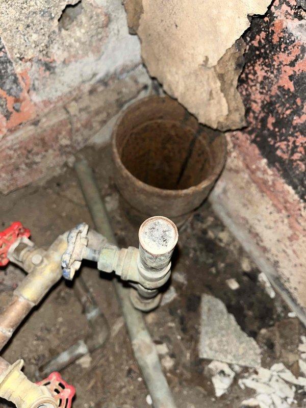 Responded to frozen pipe service call for John Marple. Inspected plumbing system using infrared thermometer to identify frozen sections in confined crawl space. Found significant pipe deterioration and rust on older metal pipes. Thawed affected pipes and noted structural concerns around clay waste pipe with deteriorating brickwork that may require future attention.