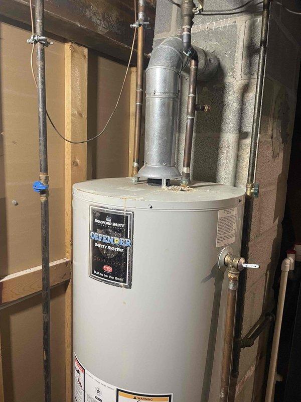 Successfully installed a Kobella tanked water heater in basement utility area as a return service. Installation included proper connection of copper inlet/outlet pipes, mounting of expansion tank, and connection of metal ventilation ducting. System includes DEFENDER safety features and all necessary valves, with all components securely mounted to the wall structure.