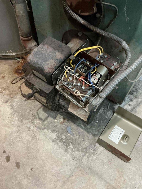 Responded to no-heat call for severely outdated oil boiler (1973 vintage) that had been malfunctioning for several years. Inspection revealed deteriorated electrical components with exposed/disorganized wiring connections and significant corrosion on the "AMERICAN" valve assembly and surrounding plumbing. System was beyond economical repair due to extensive age-related wear and component failure.