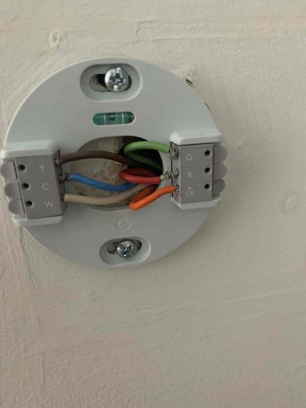 Diagnosed 10-year-old heat pump system with non-functioning cooling/heating operation while auxiliary heat remained operational. Inspection revealed faulty wiring connections at both the thermostat control panel and indoor air handler, specifically with the R, C, and OB terminals. Repaired loose and improperly terminated connections, restoring proper communication between thermostat and heat pump system.