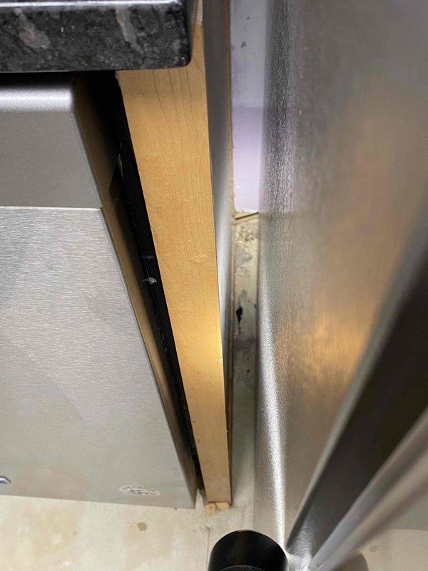 Inspected refrigerator water line leak as requested for insurance documentation purposes. Observed water damage to kitchen floor with visible moisture spots and peeling of laminate/vinyl flooring near the Maytag refrigerator installation junction. Documented evidence of water intrusion at the connection point where the refrigerator's water supply line interfaces with cabinetry.