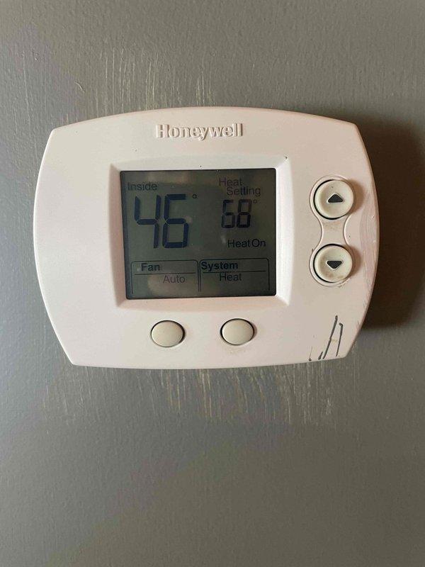 Responded to no heat complaint at residence. Found system unable to maintain temperature with thermostat reading 46°F despite 68°F heat setting. Outdoor unit was covered in snow, restricting proper airflow and operation. Cleared snow accumulation from unit, verified proper system operation, and confirmed heat restoration to home.