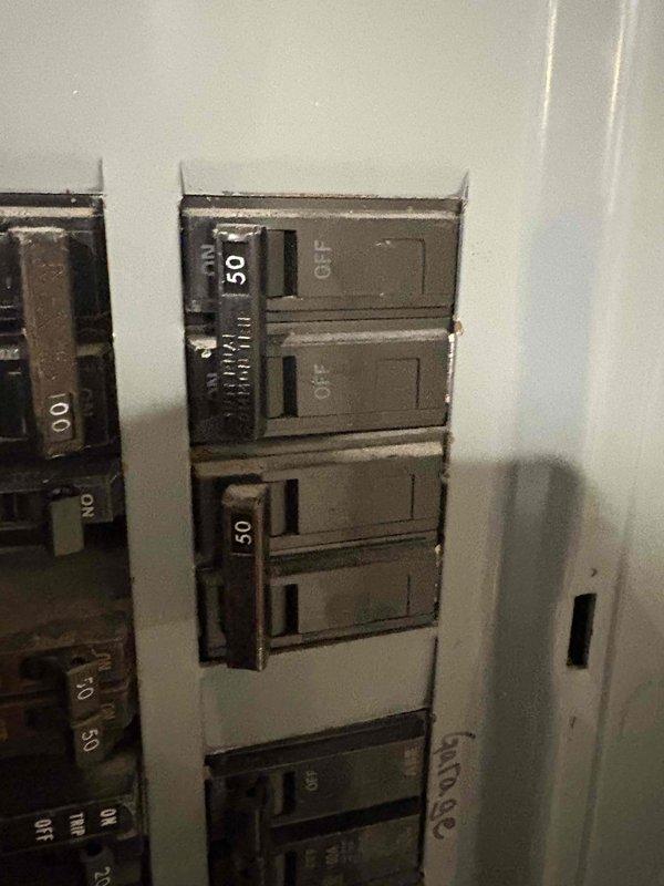Inspected customer's residence with steam boiler system to estimate installation of ductless AC system. Evaluated electrical panel capacity, noting two 50-amp breakers currently in OFF position that could potentially support new system. Measured wall access panel dimensions (31.25" x 33.5" and 39" x 37.5") to determine feasibility of running ductwork through attic space as requested by customer.