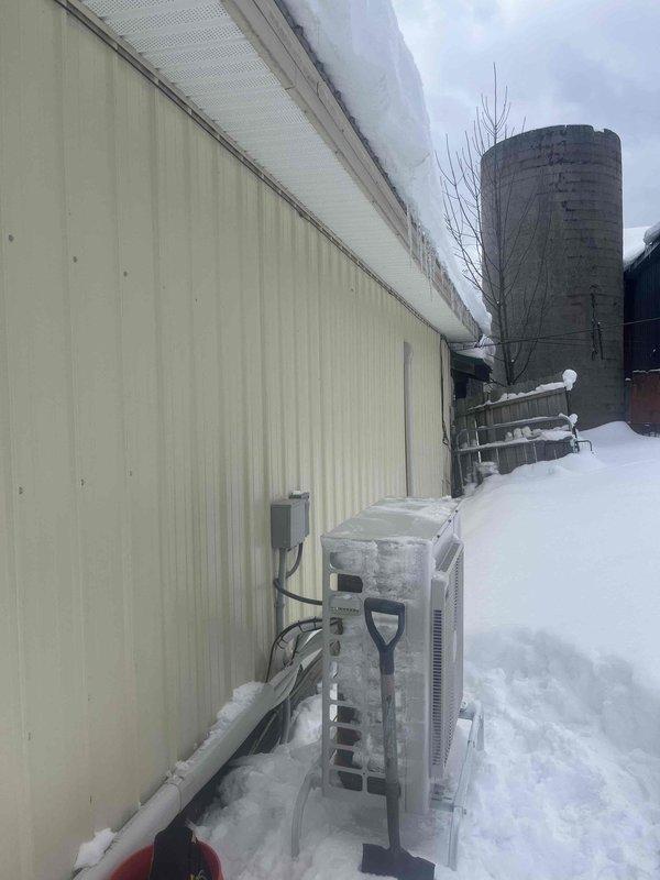 Responded to service call for commercial mini split system with no heat output. Discovered units heavily iced over due to extreme snow accumulation around outdoor condenser unit. Cleared snow/ice buildup from outdoor unit, restored proper airflow, and verified system operation with remote control set to 78°F heating mode.