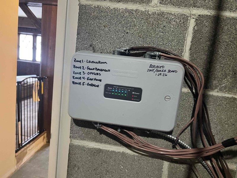 Successfully replaced defective zone control board under warranty. New board installed and tested on all five zones (Living Room, Front Basement, Offices, East Wing, and Garage). System functioning properly with normal temperature readings displayed on control panel.