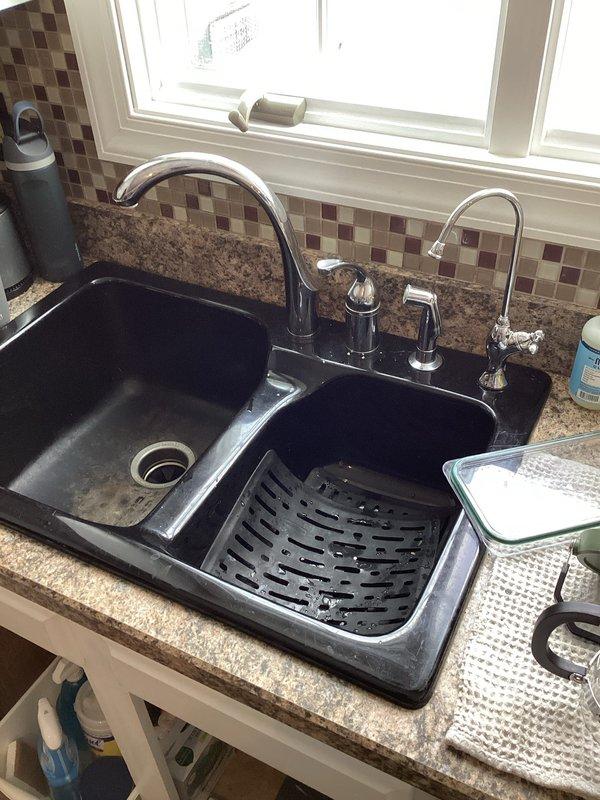 Responded to service call for bathroom faucet leak and potential kitchen sink leak. Inspected black bathroom fixtures showing signs of water damage. Identified poor water heater ventilation causing plastic components to melt; recommended relocating heater closer to b-vent or installing a power vent/tankless system to resolve ventilation issues.