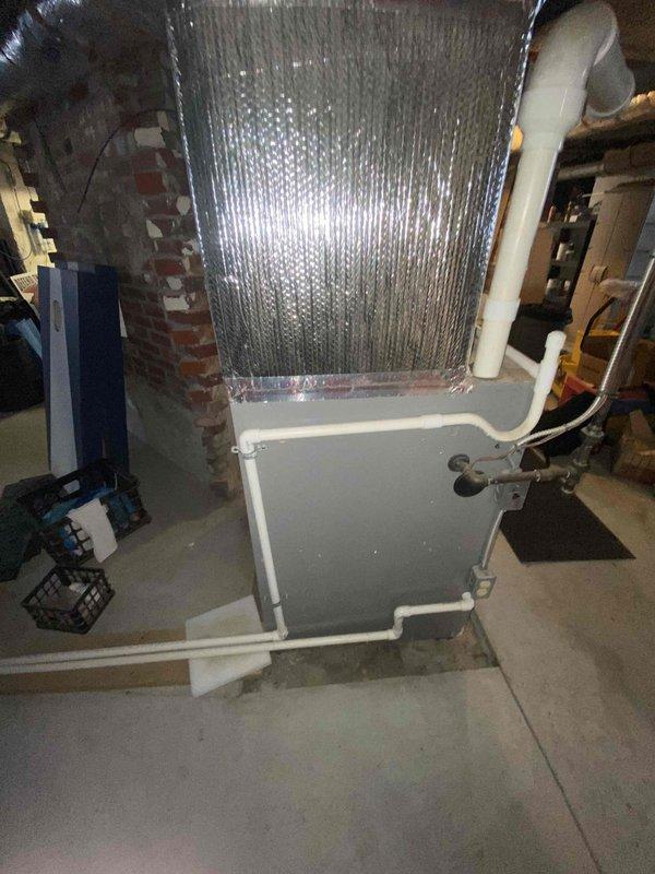 Performed site assessment for customer interested in furnace replacement with premium Lennox model, prioritizing noise reduction. Inspected existing installation, noting corroded pipe junction against brick wall and current HVAC configuration with foil-covered evaporator coil. Discussed high-efficiency, ultra-quiet Lennox options suitable for the basement installation environment.