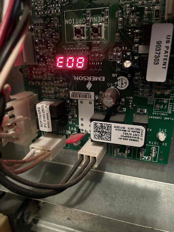 Responded to service call for non-heating furnace. Diagnosed E03 error code on Emerson control board indicating flame sensor malfunction. Removed, cleaned, and reinstalled flame sensor to restore proper flame detection. Unit now operating normally with consistent heat production.