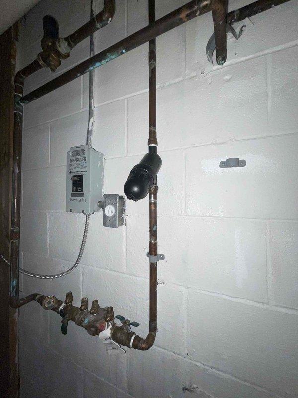 Responded to a water leak in basement. Located obsolete black filter on water pipe from previous well water system that was causing leakage. Since property now uses city water, removed unnecessary filter component and verified proper function of the main water supply system.