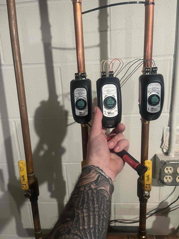 Diagnosed overheating issue in dining room where thermostat was reading 82°F despite being off. Inspected and replaced faulty Taco PBVF2 2-way zone valve controllers that were causing improper flow control. Verified proper operation of temperature sensors on supply lines and confirmed system now maintaining proper temperature control.