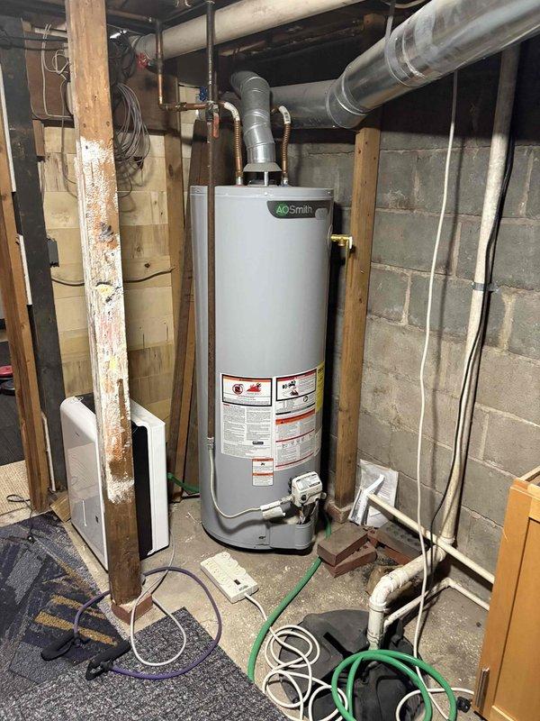Conducted assessment of 30-year-old furnace system with random failure issues. Inspection revealed aging HVAC infrastructure with deteriorated ductwork connections and outdated components in basement utility area. Recommended complete system replacement to address reliability concerns and improve efficiency, including new furnace unit and proper integration with existing A.O. Smith water heater setup.