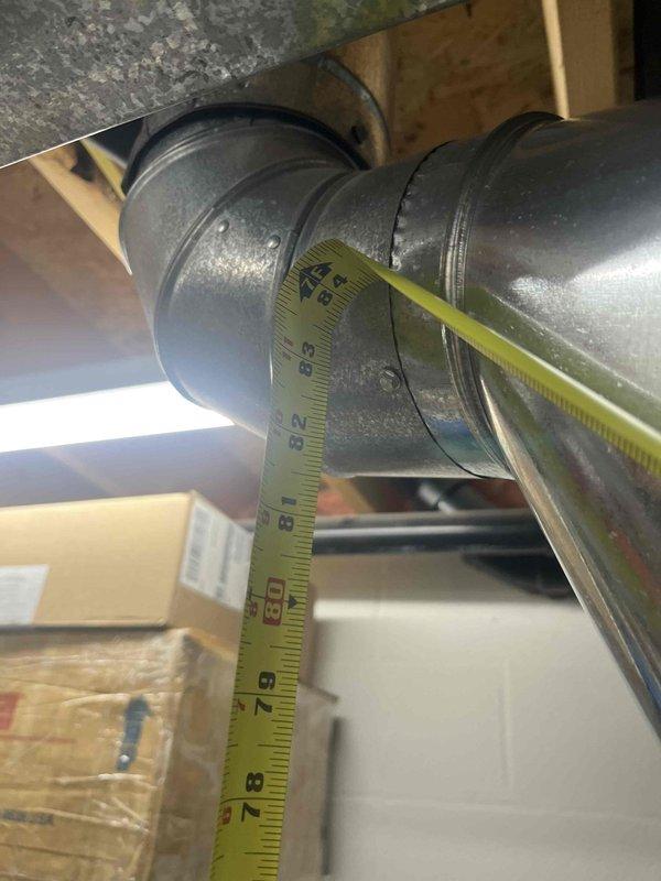 Conducted inspection of existing 50-gallon gas water heater with standard atmospheric venting. Measured tank dimensions and vent pipe diameter (approximately 7-8 inches) to assess replacement options. Customer is considering upgrade to more energy-efficient model; provided information on high-efficiency alternatives.