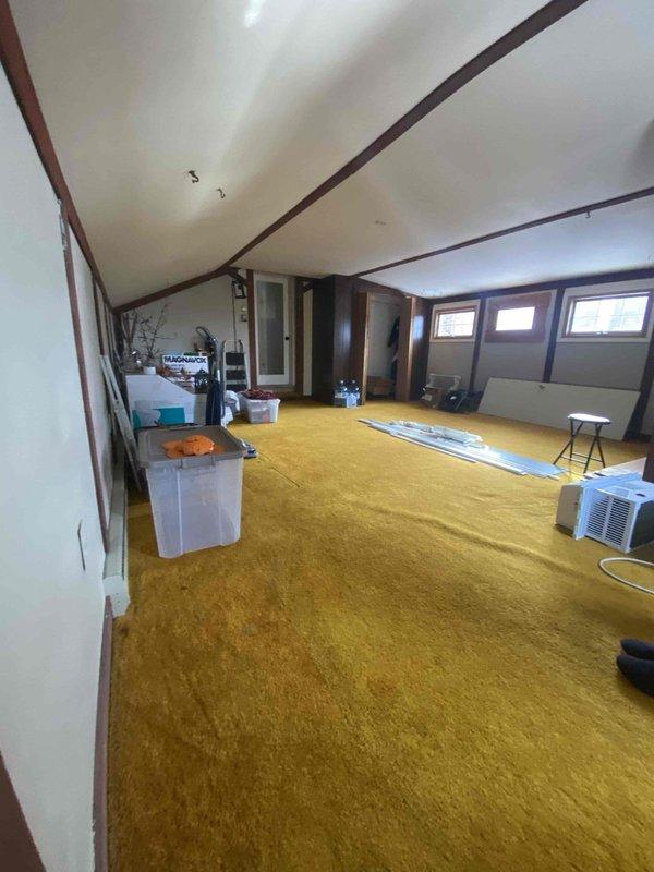 Conducted site assessment for potential mini split installation in an upper-level room with sloped ceiling. Room features carpeted flooring, multiple windows, and limited wall space. Identified optimal location for indoor head unit on exterior wall near window. Customer is coordinating with plumbing service for additional requirements.