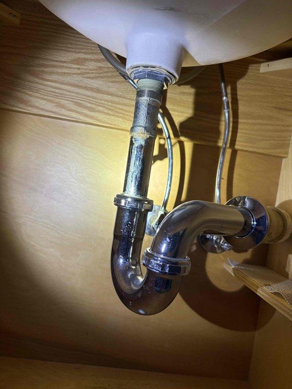 Responded to a service call for dripping shower head and faucet in second floor bathroom. Inspected P-trap assembly and plumbing under sink, noting mineral buildup and signs of wear. Serviced shower control valve, addressing mineral deposits on chrome fixture and resolving the persistent drip issue.